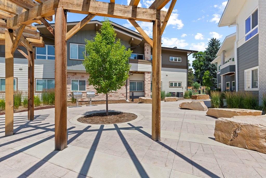 a view of a courtyard with a tree and buildings in the background