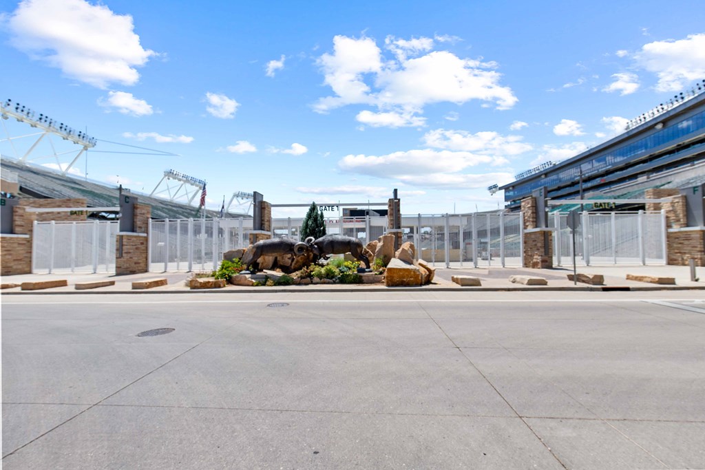 A large open space with a fenced-off area in the middle and a stadium in the background.