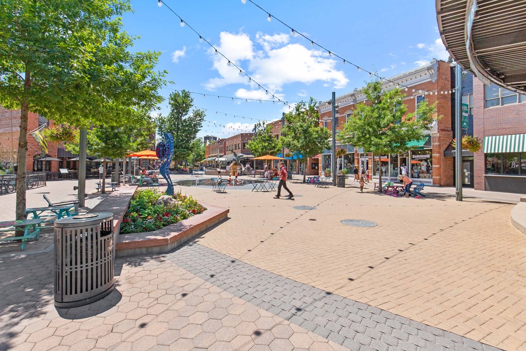 A sunny day in a pedestrian plaza with a person walking.