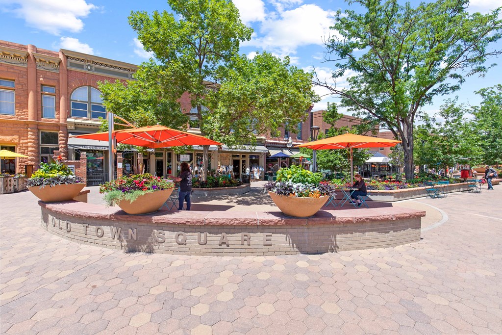 a fountain with umbrellas in the middle of a city street