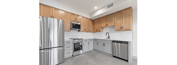 A modern kitchen with wooden cabinets and stainless steel appliances.