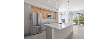 A modern kitchen with a refrigerator, microwave, and a countertop.