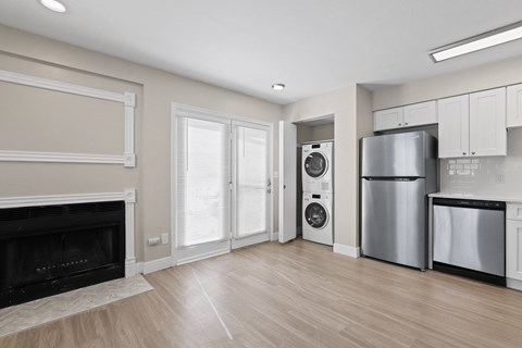 a living room with a fireplace and a refrigerator and a washing machine