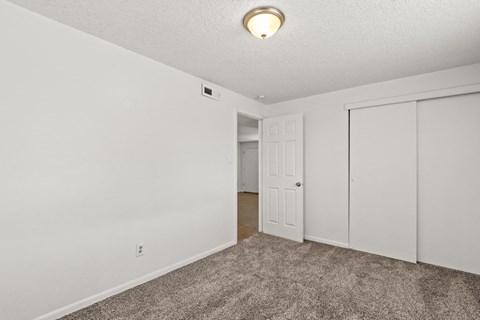a bedroom with a carpeted floor and white walls