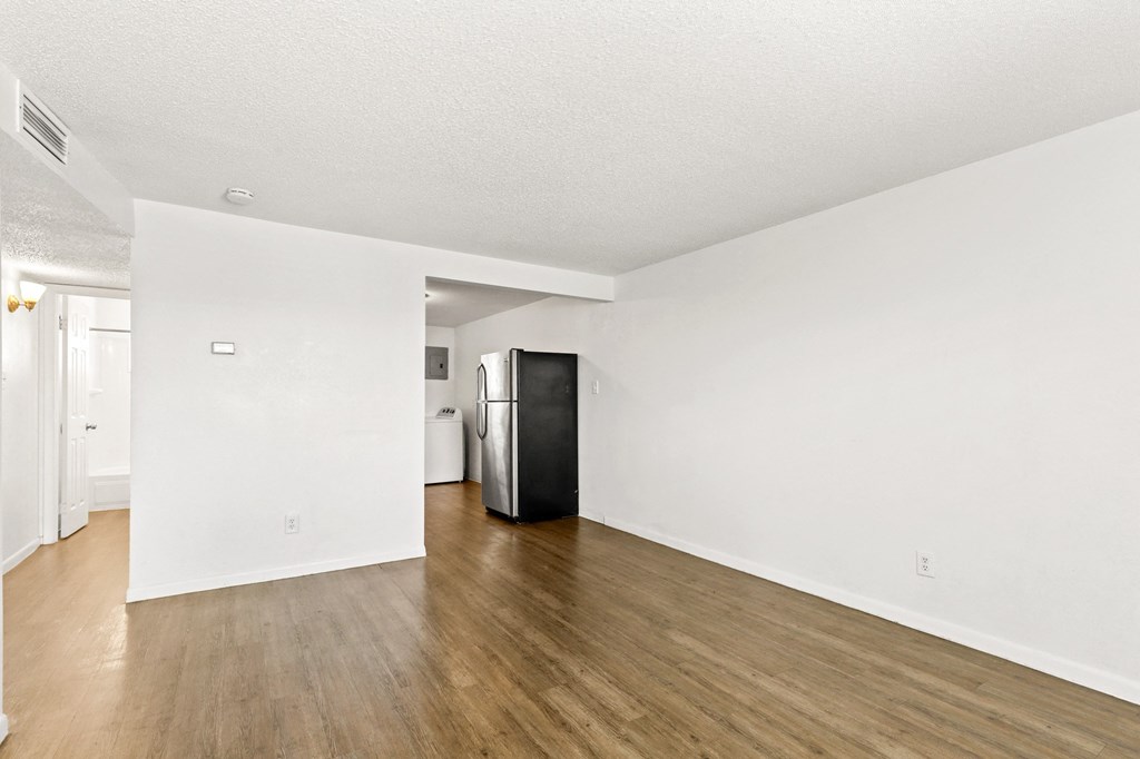a bedroom with hardwood flooring and white walls