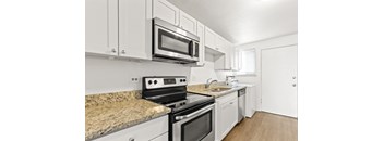a kitchen with white cabinets and granite countertops