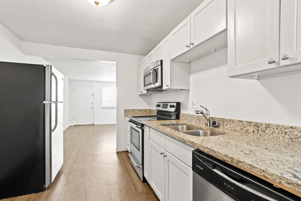 a kitchen with white cabinets and granite countertops