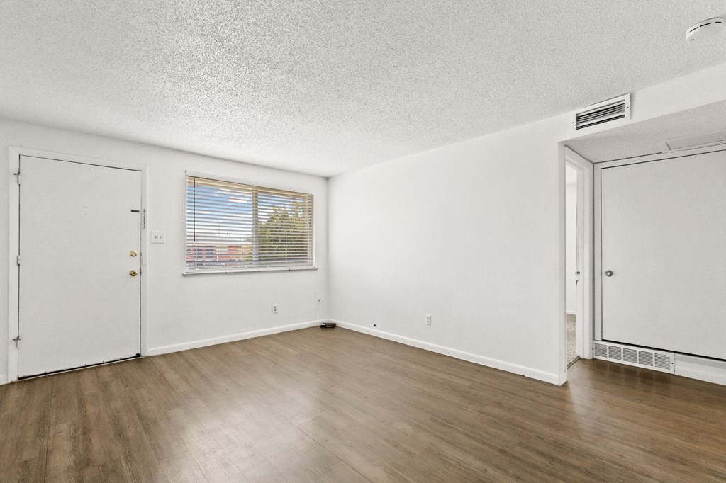 a bedroom with hardwood floors and white walls
