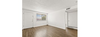 a bedroom with hardwood floors and white walls