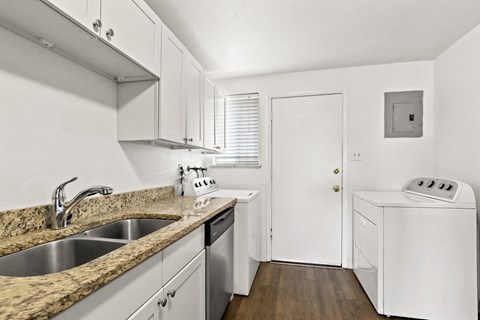 a kitchen with white cabinets and a counter top and a sink