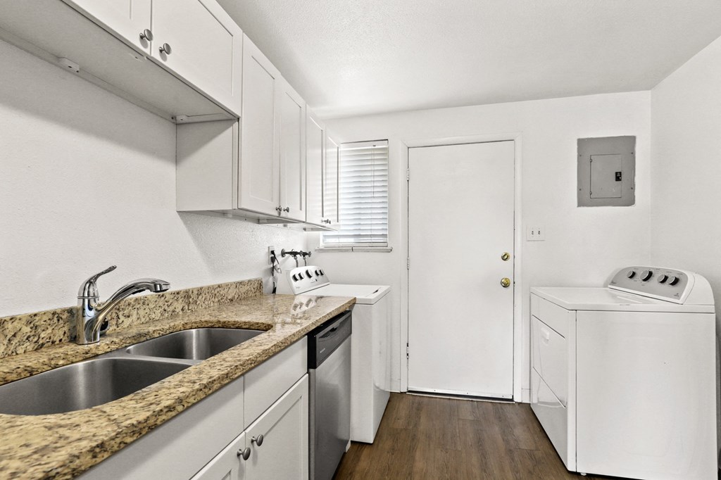 a kitchen with white cabinets and a white washer and dryer