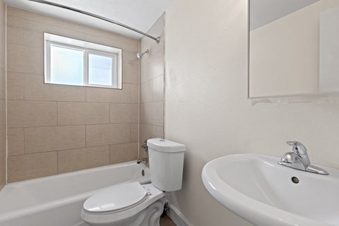 a bathroom with a toilet and a sink and a window