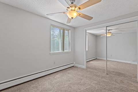 a bedroom with a ceiling fan and a mirror
