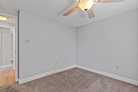 the living room of an empty house with a ceiling fan