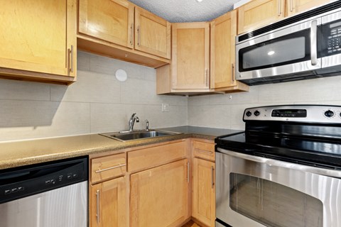 a kitchen with wooden cabinets and appliances and a sink