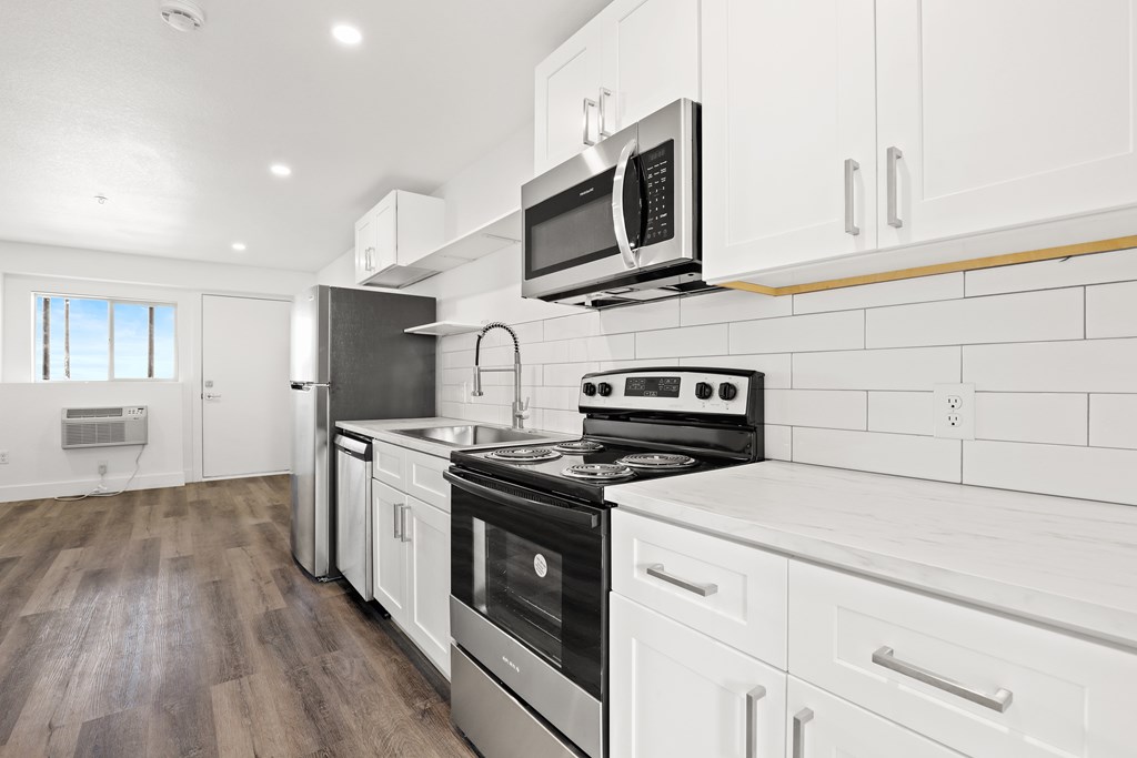 a kitchen with white cabinets and a stove and a microwave