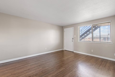 Empty room with wooden flooring and a window.