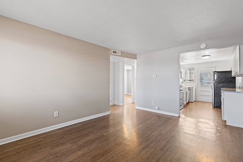 A spacious room with wooden flooring and a white ceiling.