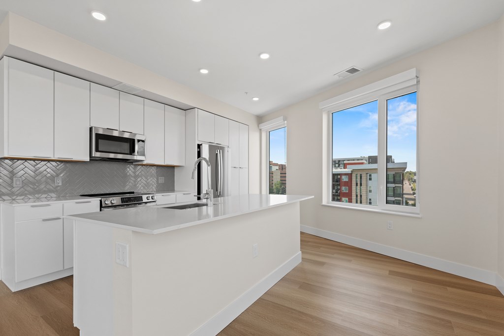 A kitchen with white cabinets and a large island.