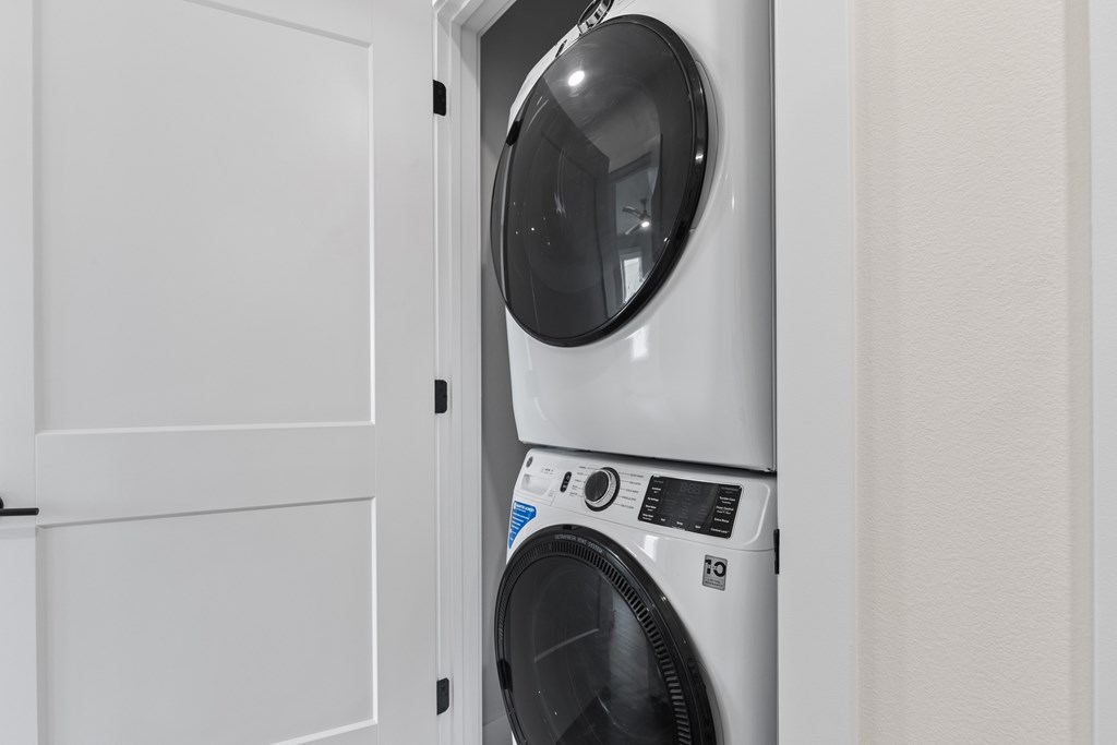 A white washing machine is placed in a white door.