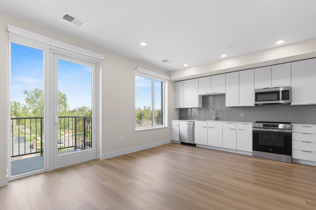A modern kitchen with white cabinets and stainless steel appliances.