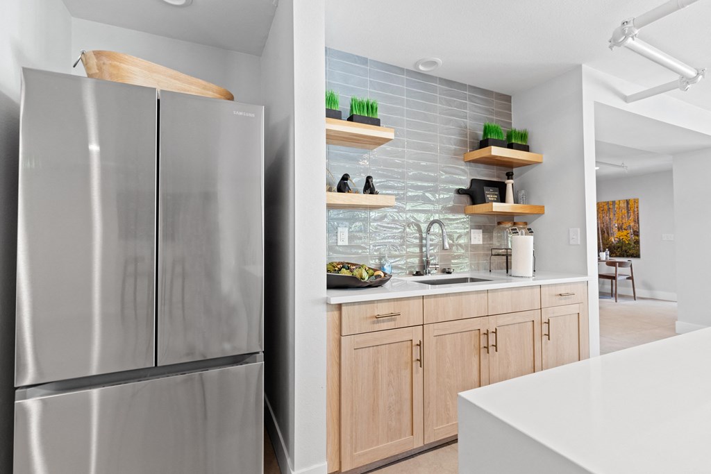 a kitchen with a stainless steel refrigerator and wooden cabinets