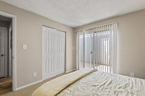 Large bedroom with sliding glass doors to a balcony