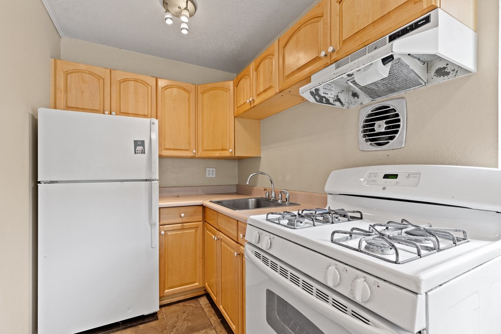a kitchen with white appliances and wood cabinets