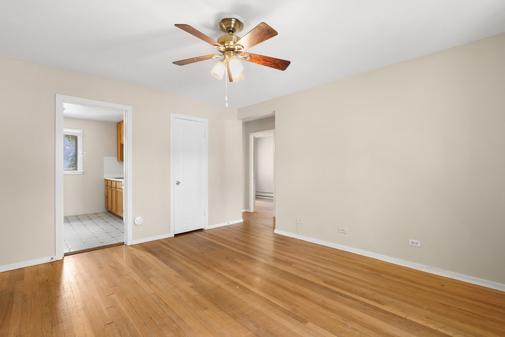 a living room with wood floors and a ceiling fan