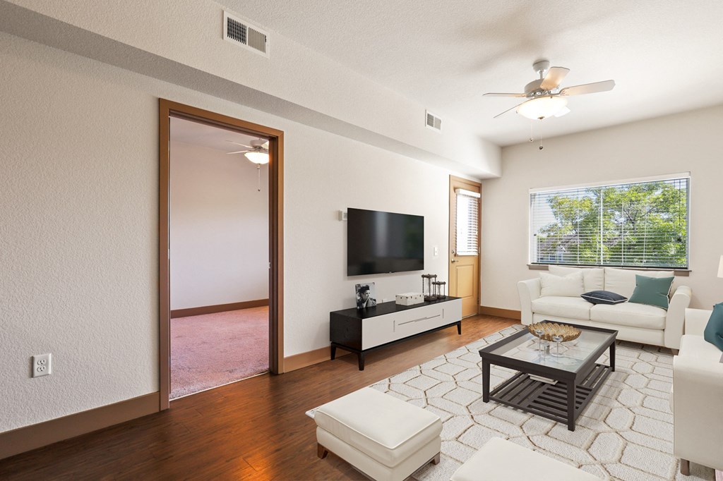 a living room with a white couch and a television