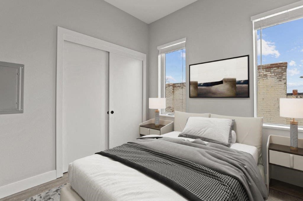 a bedroom with a bed and two windows