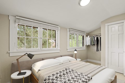 A bedroom with a large bed and a window with blinds.