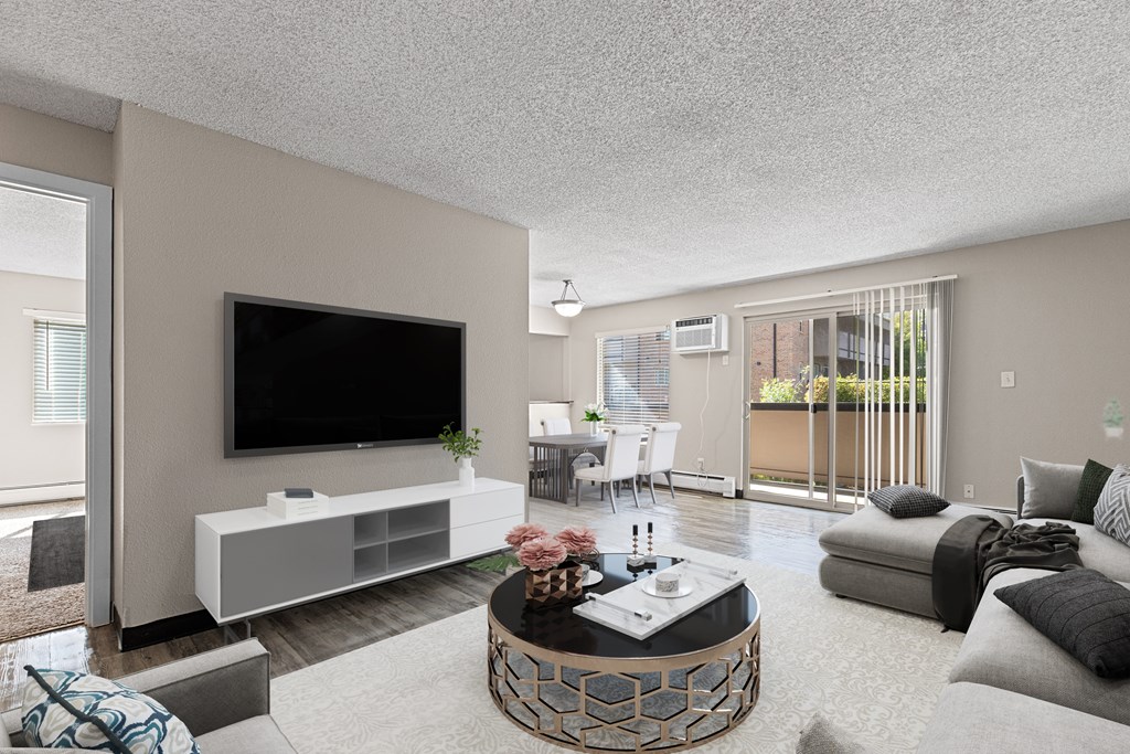 A modern living room with a flat screen TV, a white entertainment center, and a coffee table with a vase of flowers on it.