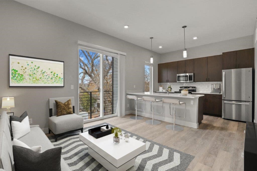 a white living room with a kitchen and a table