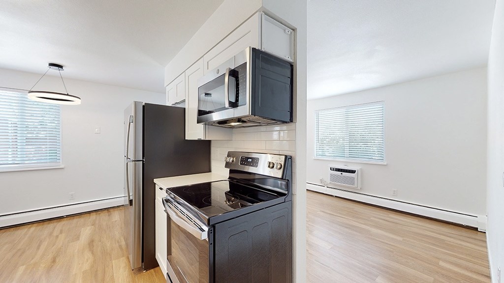 A modern kitchen with a black fridge and stove.