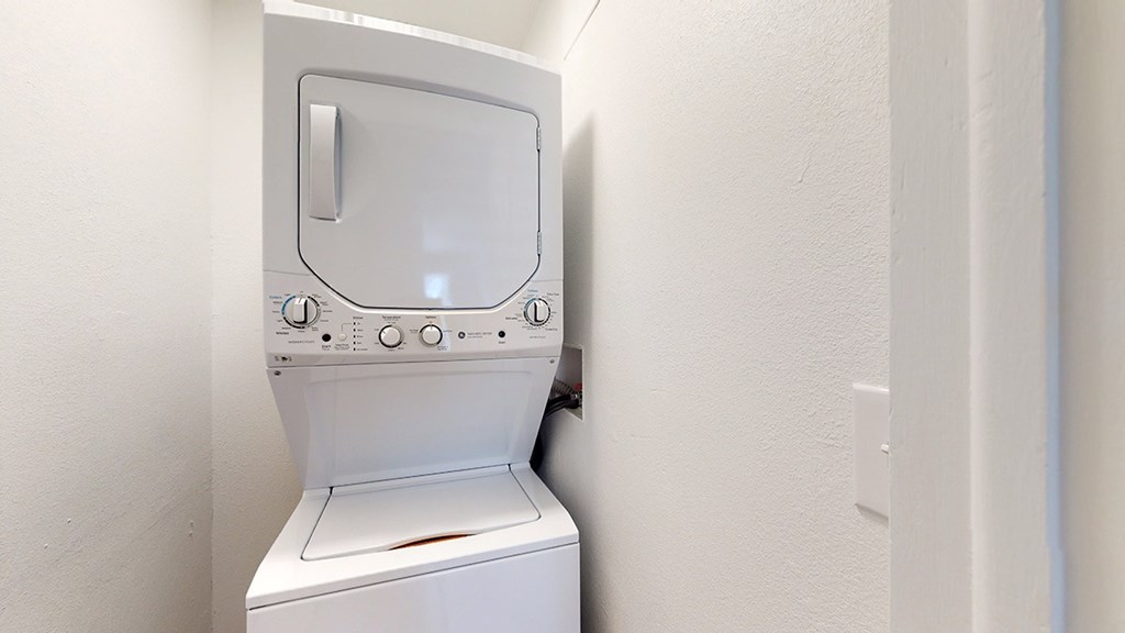 A white washing machine in a small room.