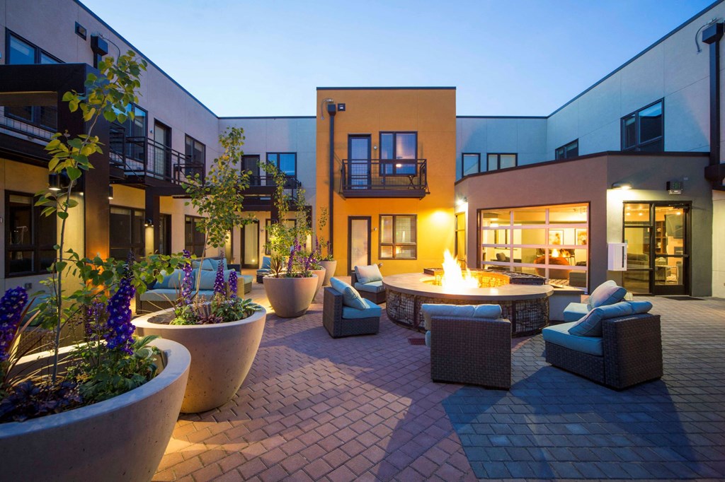 a courtyard with chairs and a fire pit at night
