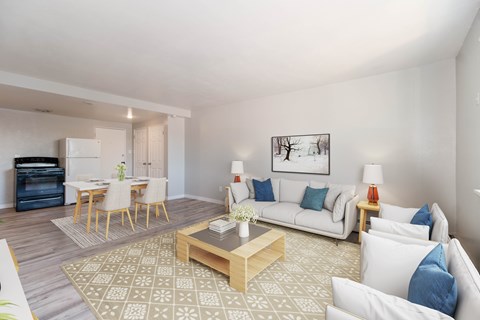 A living room with a white couch, a coffee table, and a painting on the wall.