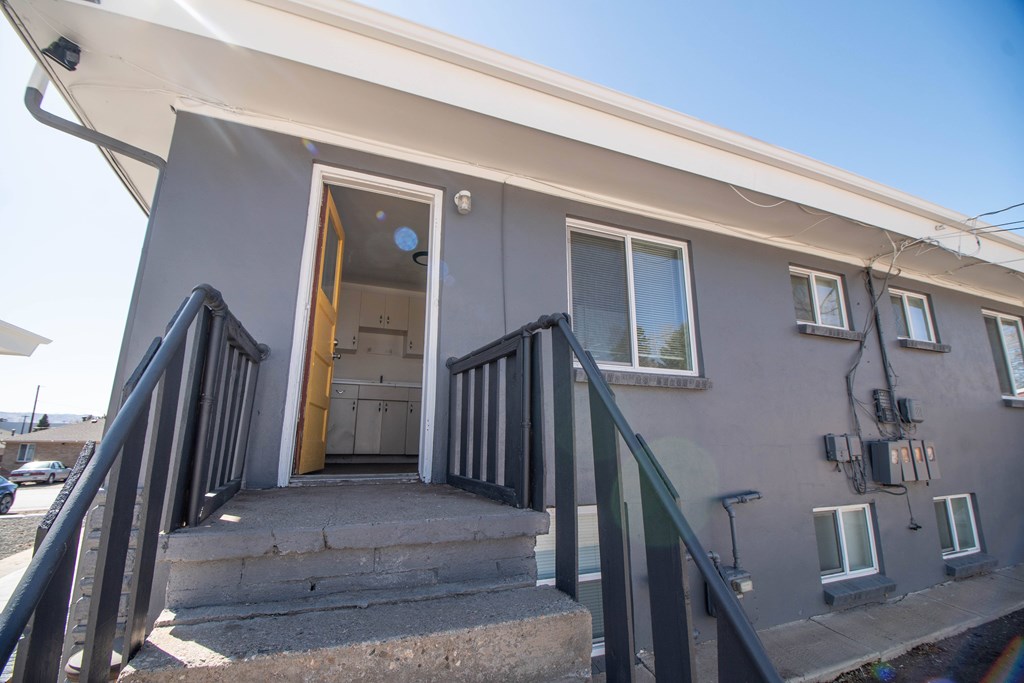 A house with a grey exterior and a yellow door.