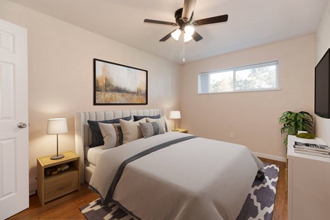 A bedroom with a large bed, a ceiling fan, and a painting on the wall.