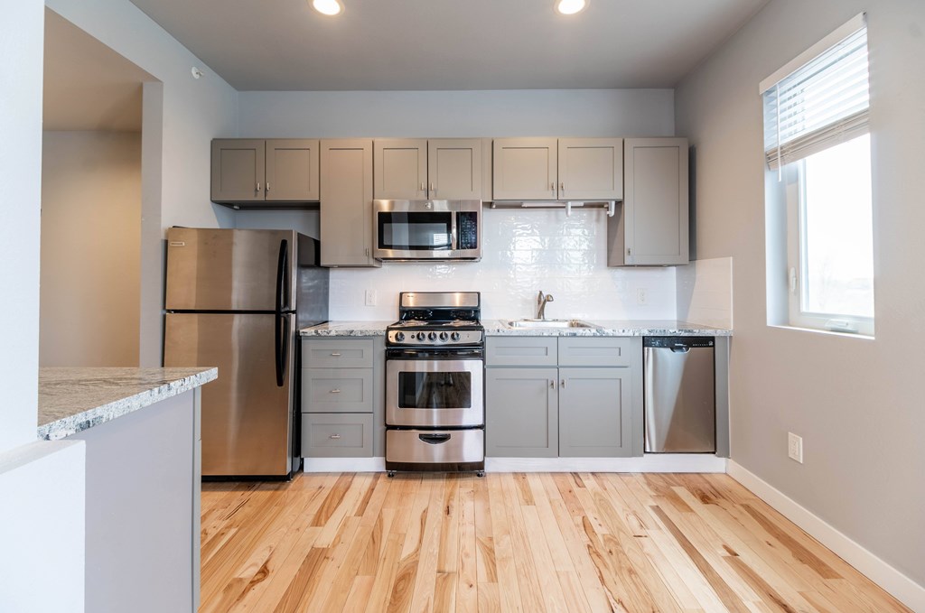 A kitchen with wooden floors and stainless steel appliances.