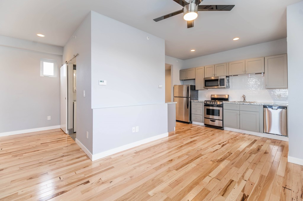 A kitchen with a refrigerator, oven, and microwave.