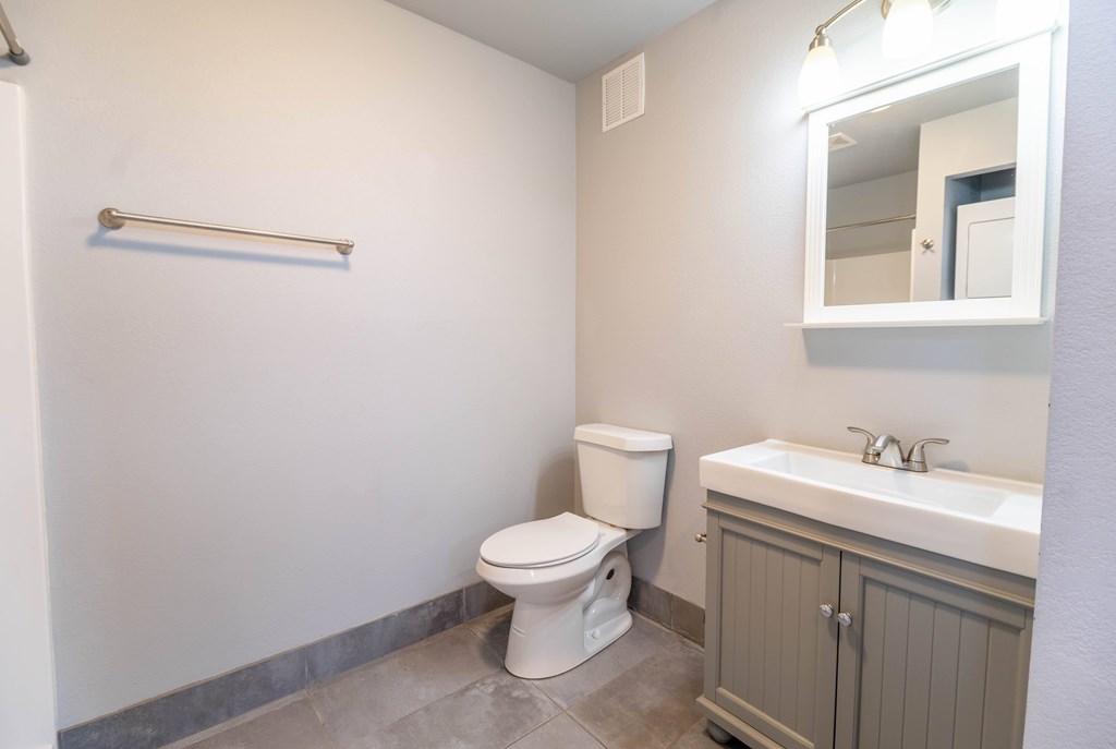 A white toilet sits next to a sink in a bathroom.