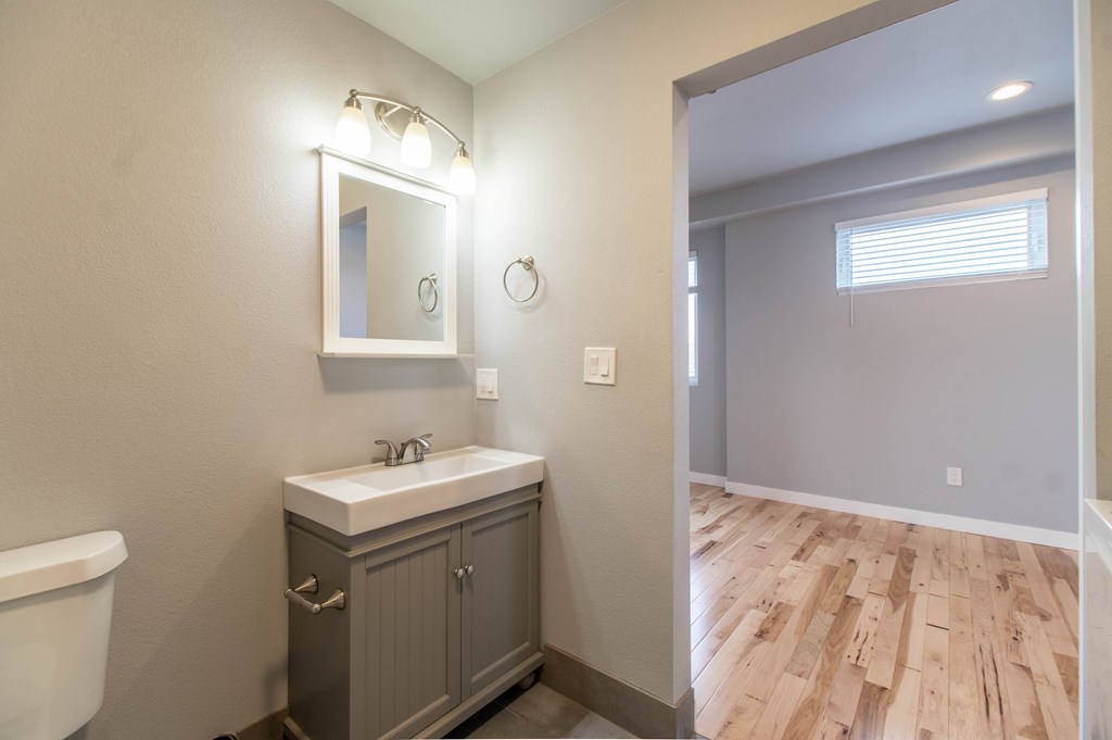 A bathroom with a white sink and a mirror above it.