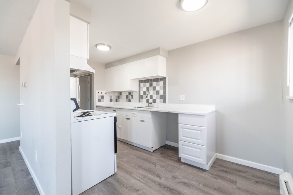 A white kitchen with a dining table and chairs.