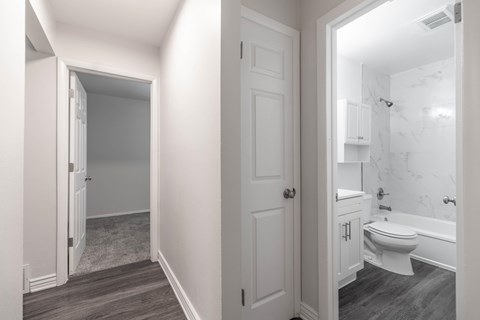 A white bathroom with a toilet and a bathtub.