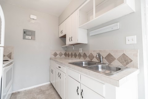 A kitchen with white cabinets and a tile backsplash.