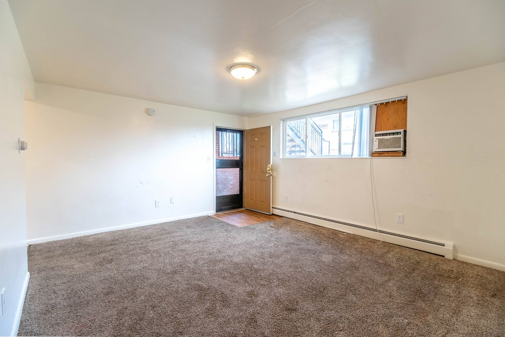 A room with a brown carpet and a brown door.