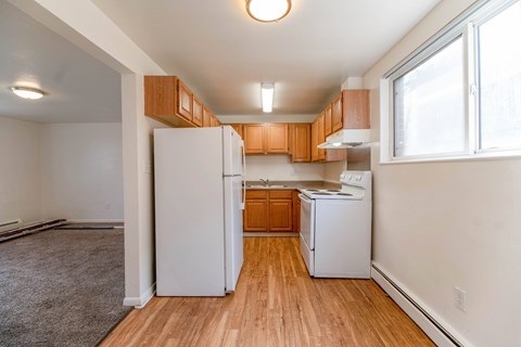 A kitchen with white appliances and wooden cabinets.