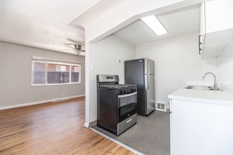 A kitchen area with a stove, refrigerator, and sink.